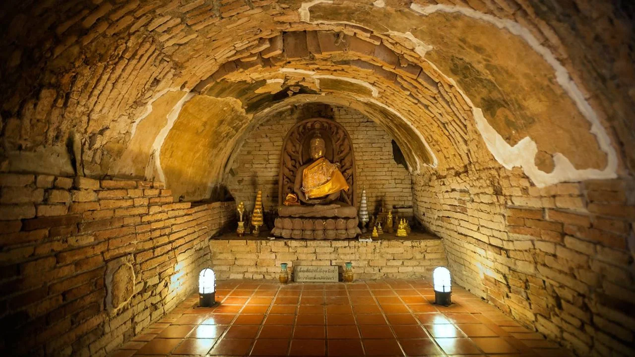 Wat Umong ancient tunnel with Buddha statue and candles