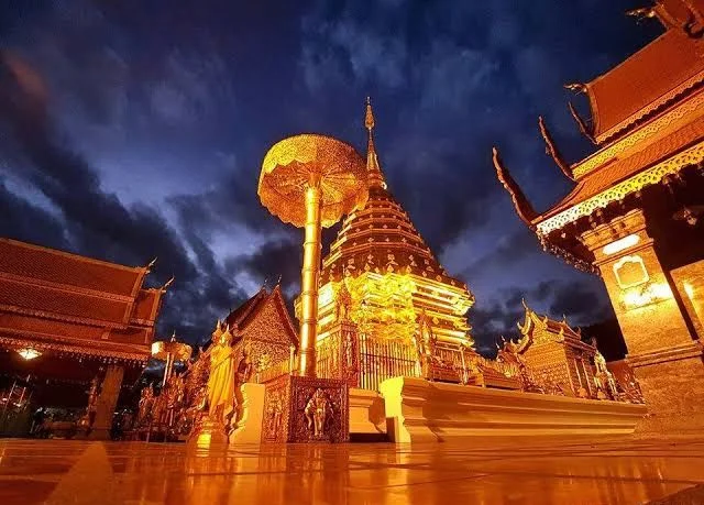 Doi Suthep Temple golden chedi at twilight with dramatic sky