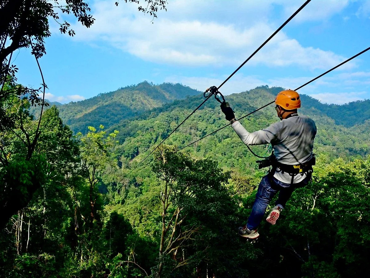 Ziplining through lush green mountains with safety equipment